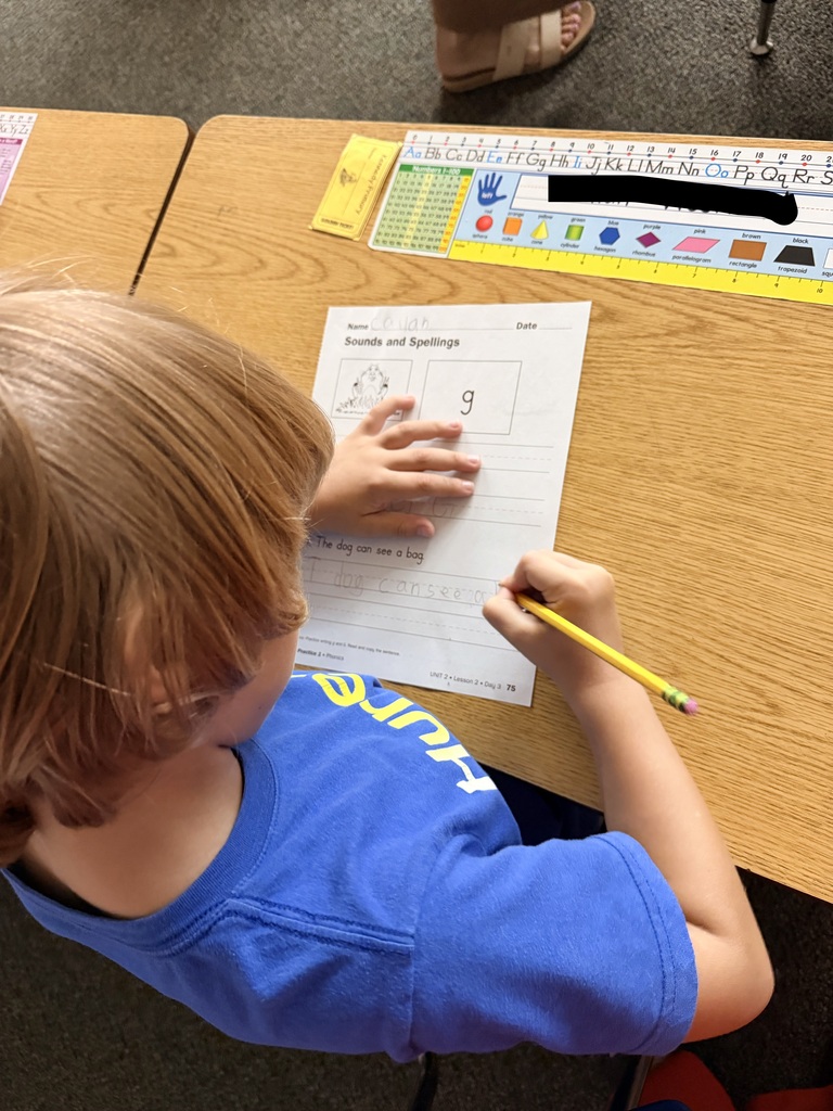 1st graders writing a sentence.