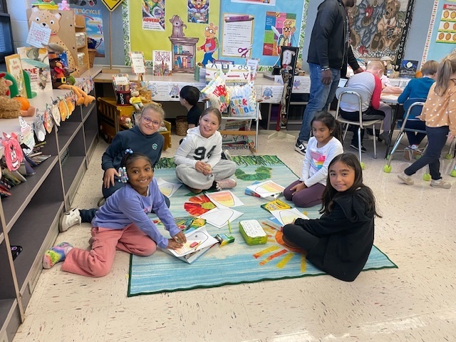 Third and first graders working together on the floor.