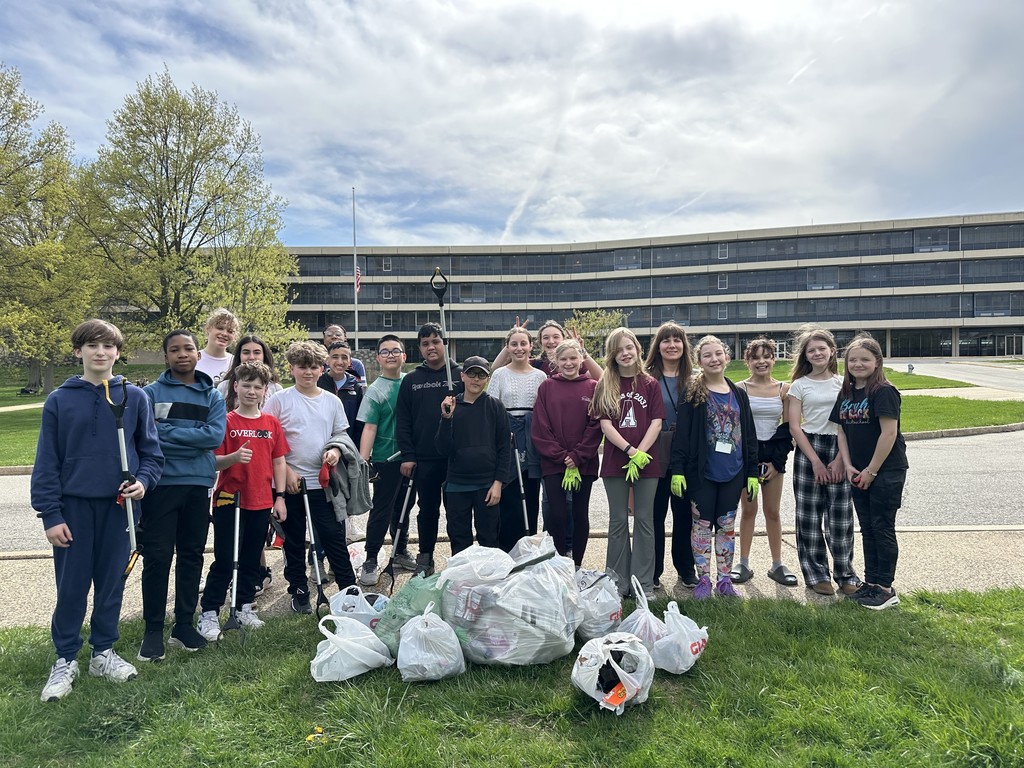 Image of middle school students posing with bags of trash for Earth Day.