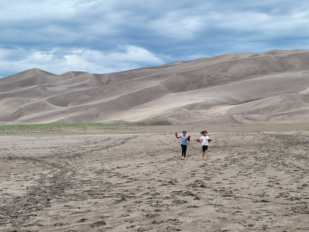 Michelle and Melanie run on the sand during a family RV trip to Colorado & Utah