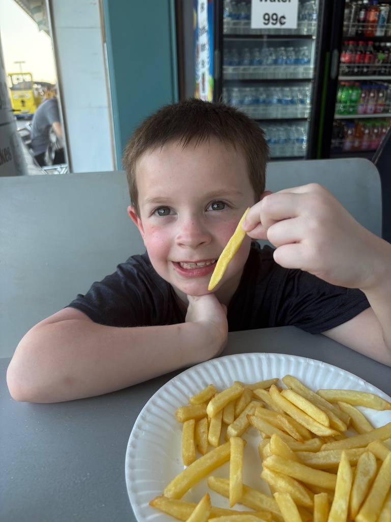 Mason picks up one french fry to eat from a plateful while in Wildwood, NJ