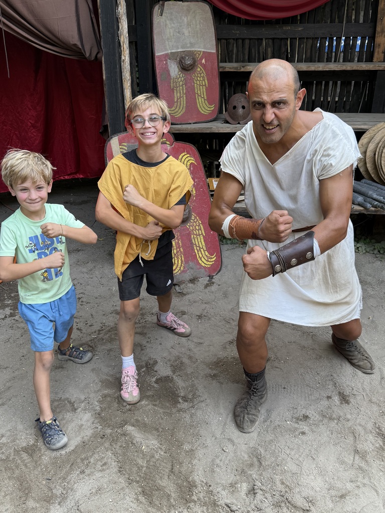 Lucas and Oliver practicing  gladiator moves with a man dressed as a gladiator