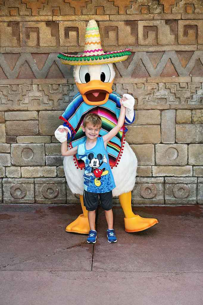 Eric stands in front of a beautiful stone block wall with Donald Dusk holding his hands from behind