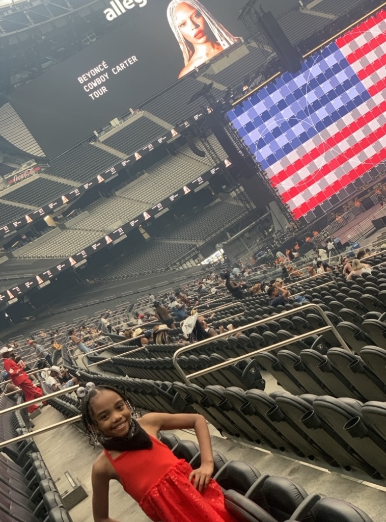 Mckesson stands in a concert arena with bright lights forming the shape of the American flag