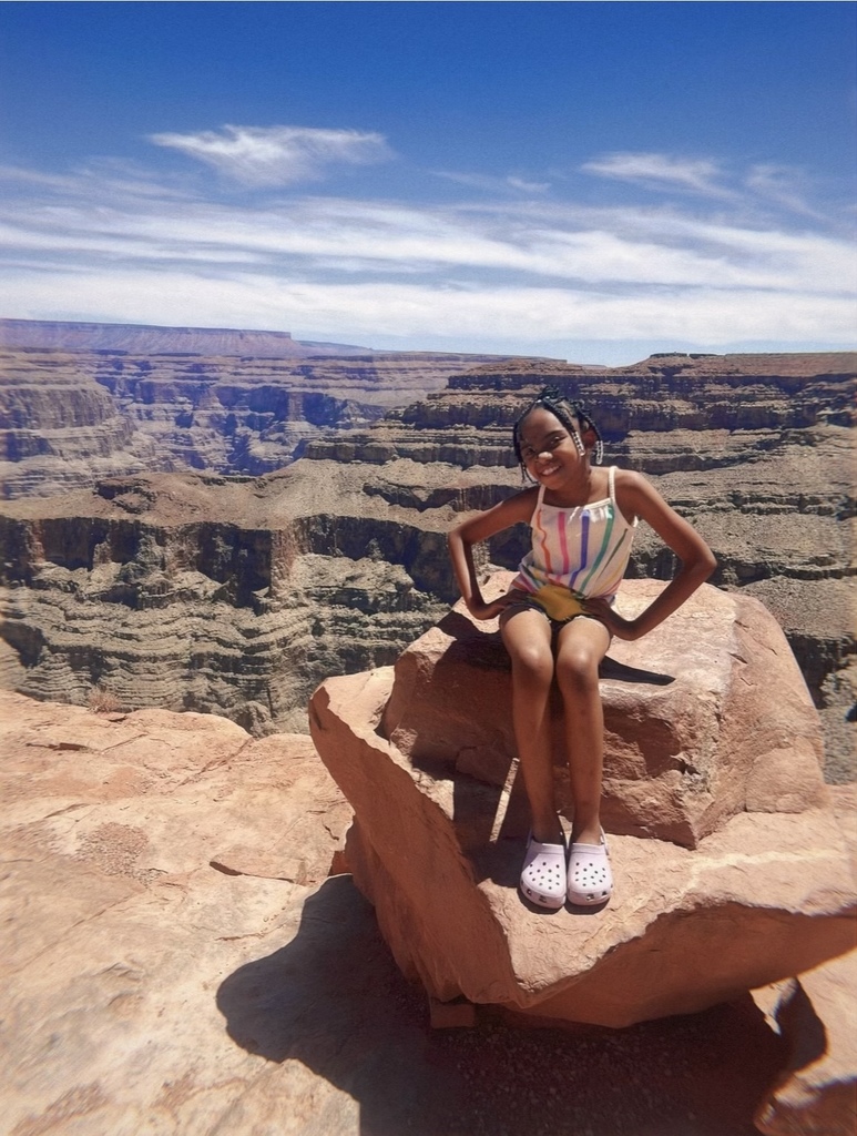 Mckesson sits in a huge rock at the top of a ridge in Nevada, with the canyon in the background