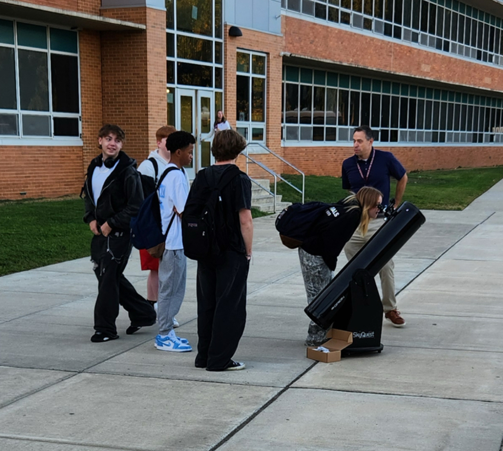 Students look through Mr. Anderson's telescope