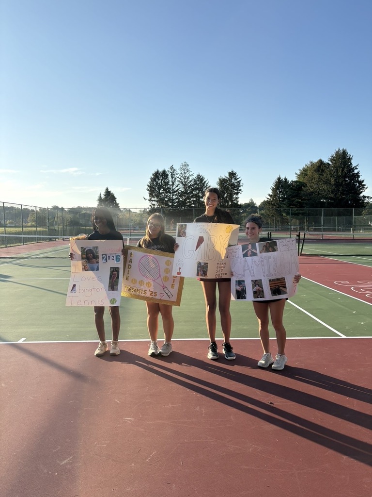 A picture of the tennis varsity seniors holding their posters 
