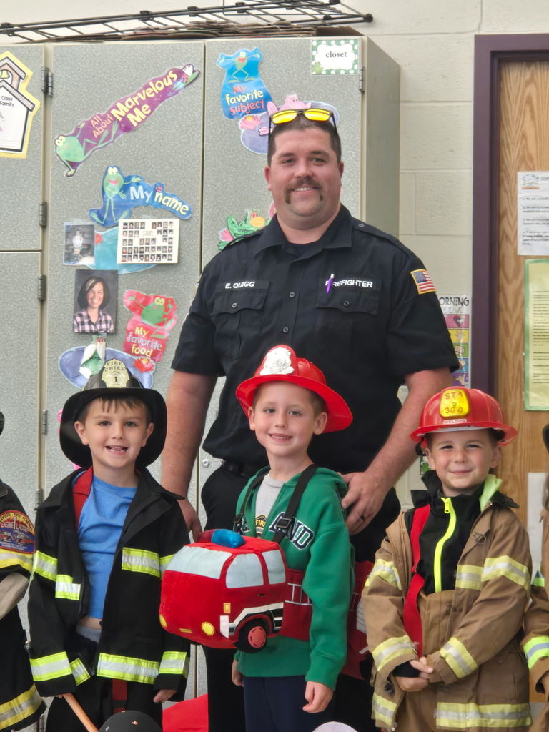 students smiling with a firefighter