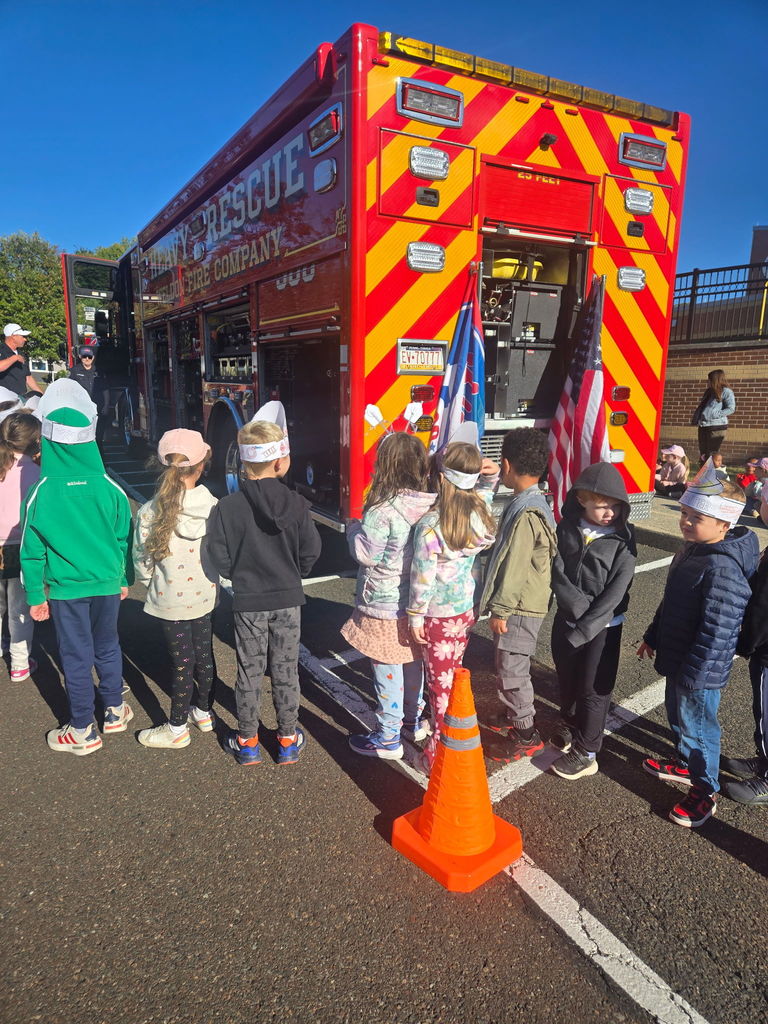 students smiling with a firetruck