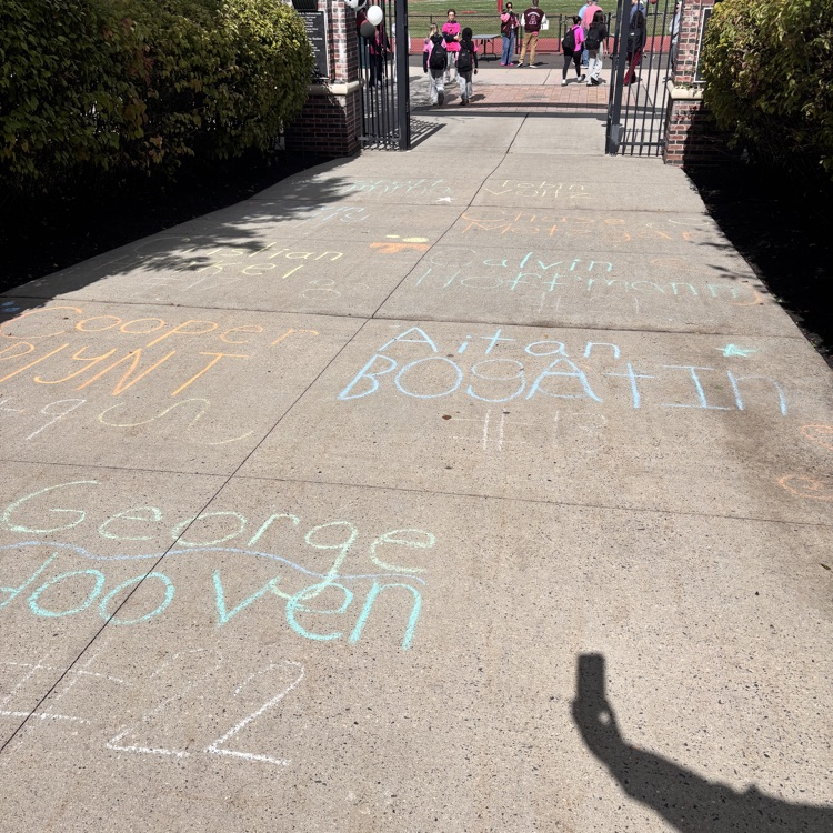 Chalked names of hoco court on sidewalk outside of stadium