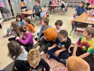 students looking at a pumpkin