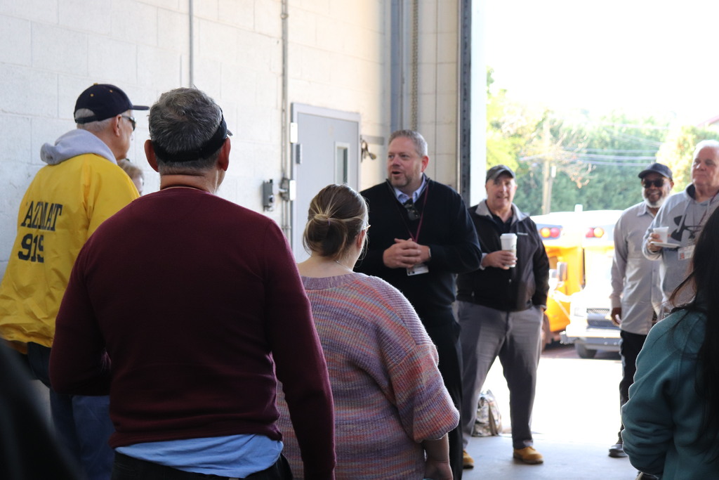 Dr. Fecher recognizes the work of bus drivers at a gathering at the bus garage