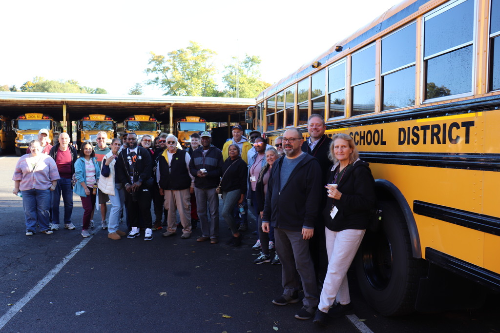 Dr. Fecher with the Transportation Department in front of an ASD school bus