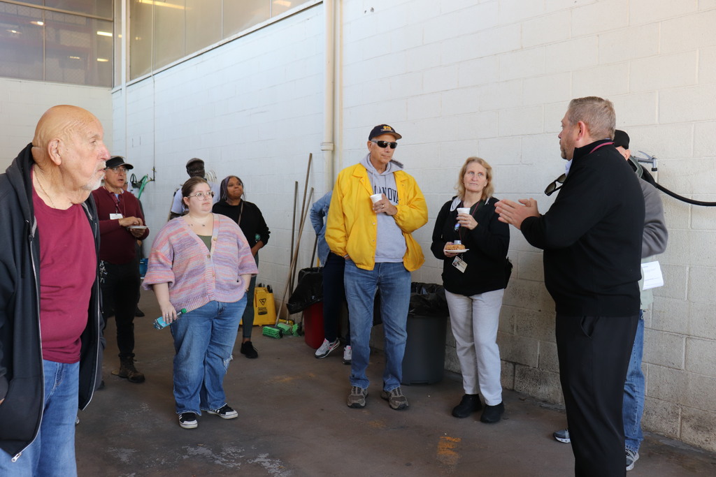 Dr. Fecher recognizes the work of bus drivers at a gathering at the bus garage
