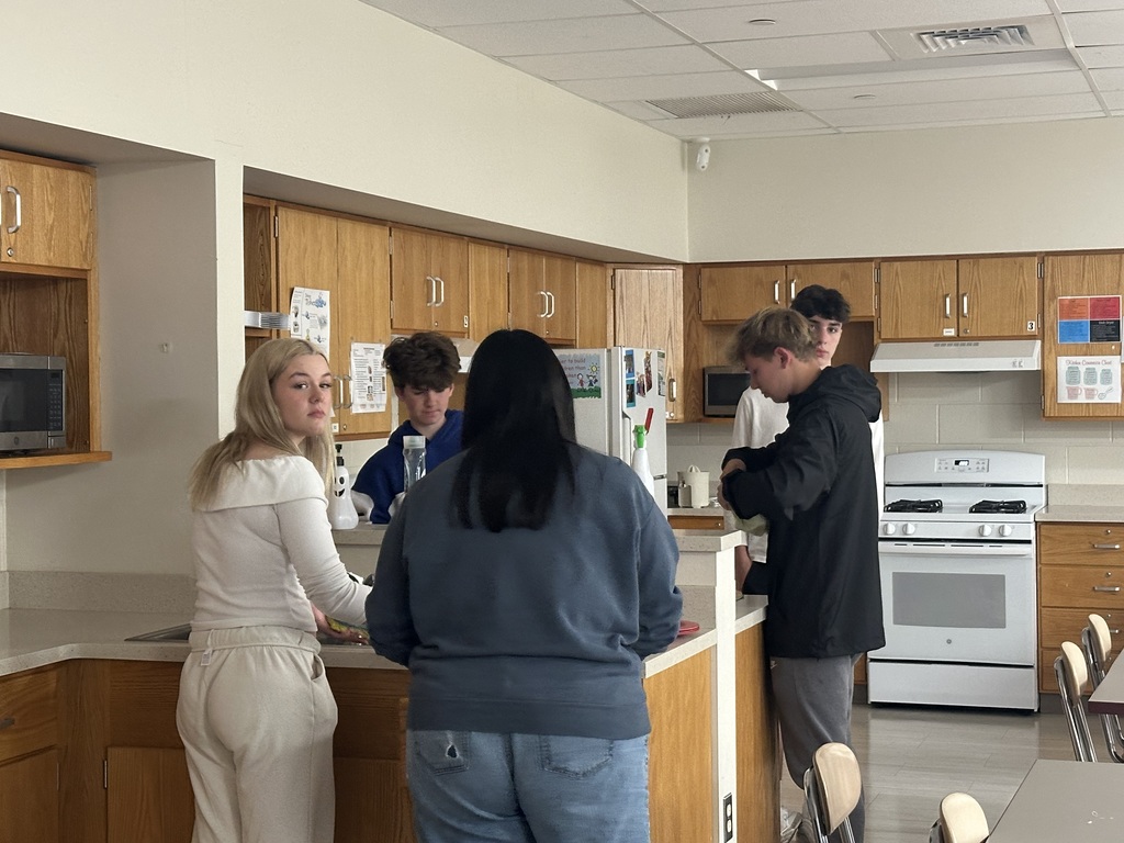 Students are washing the dishes after cooking yummy cookies.