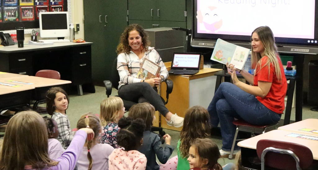 Teachers read to students sitting on the floor, for Overlook's Reading Night