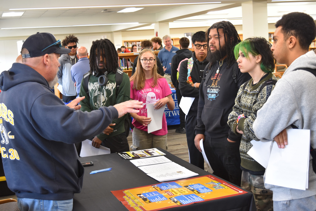 A union rep speaks to students who are gathered around his table of literature