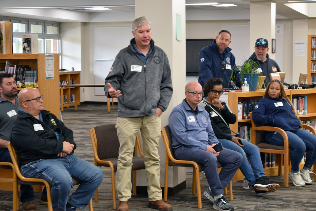 A union rep stands in the row of reps and speaks to students