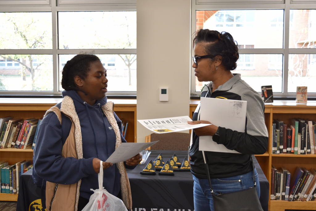 A female union rep speaks to a female student, holding literature