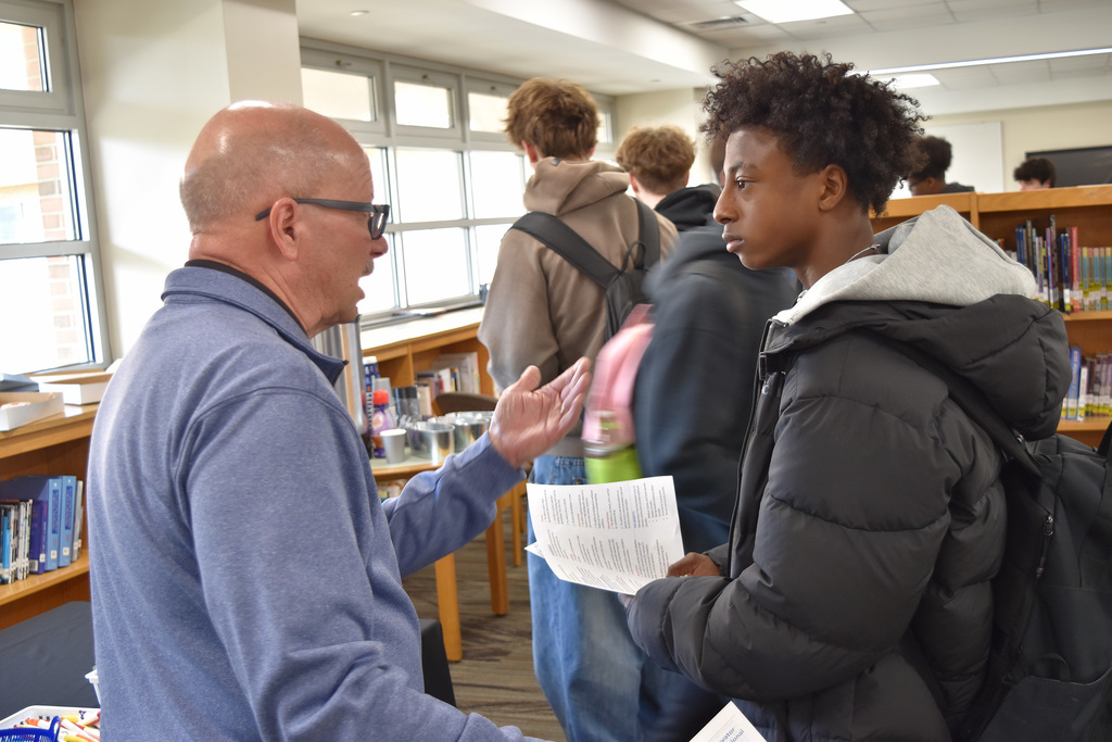 A union rep speaks to a student holding literature