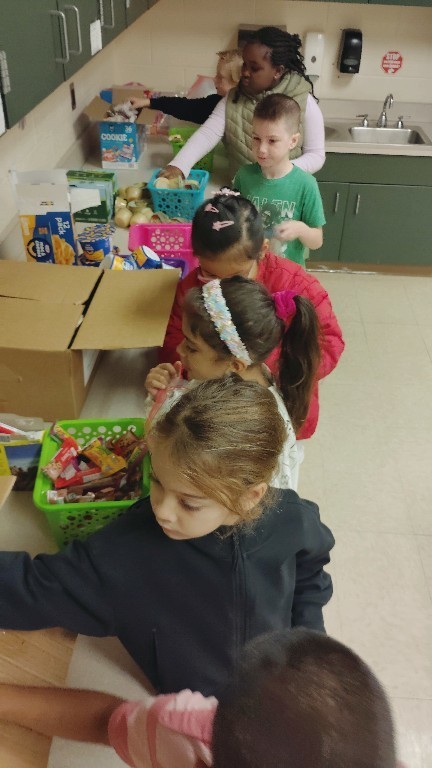 Overlook students move through a line of food items, filling their Belly Bags for those in need
