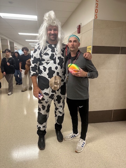 Mr Martin with a friend dressed like a cow and sportsmen