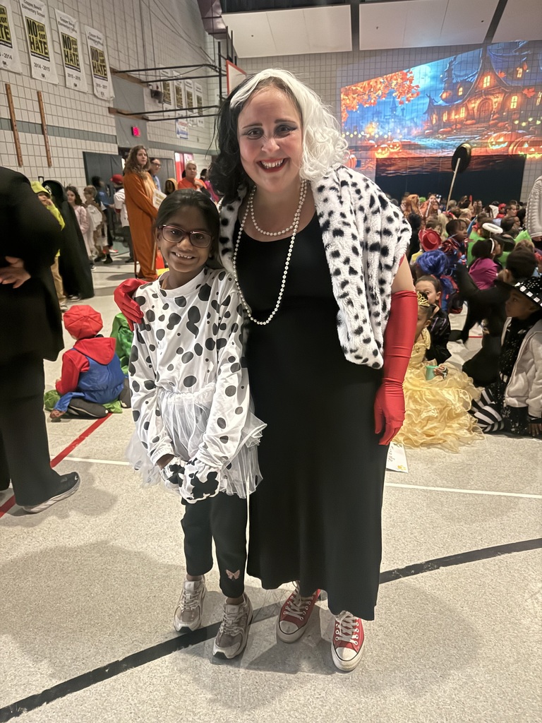 Mrs. Cashman smiling with a student in their costumes
