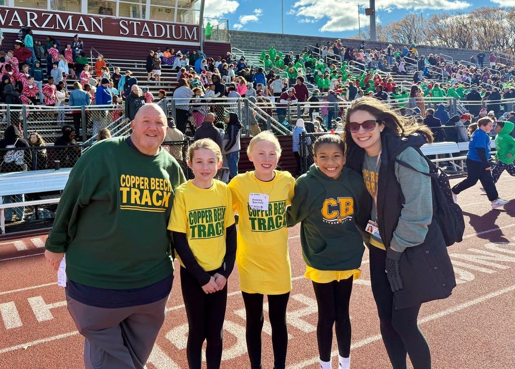 students and staff smiling at the track meet
