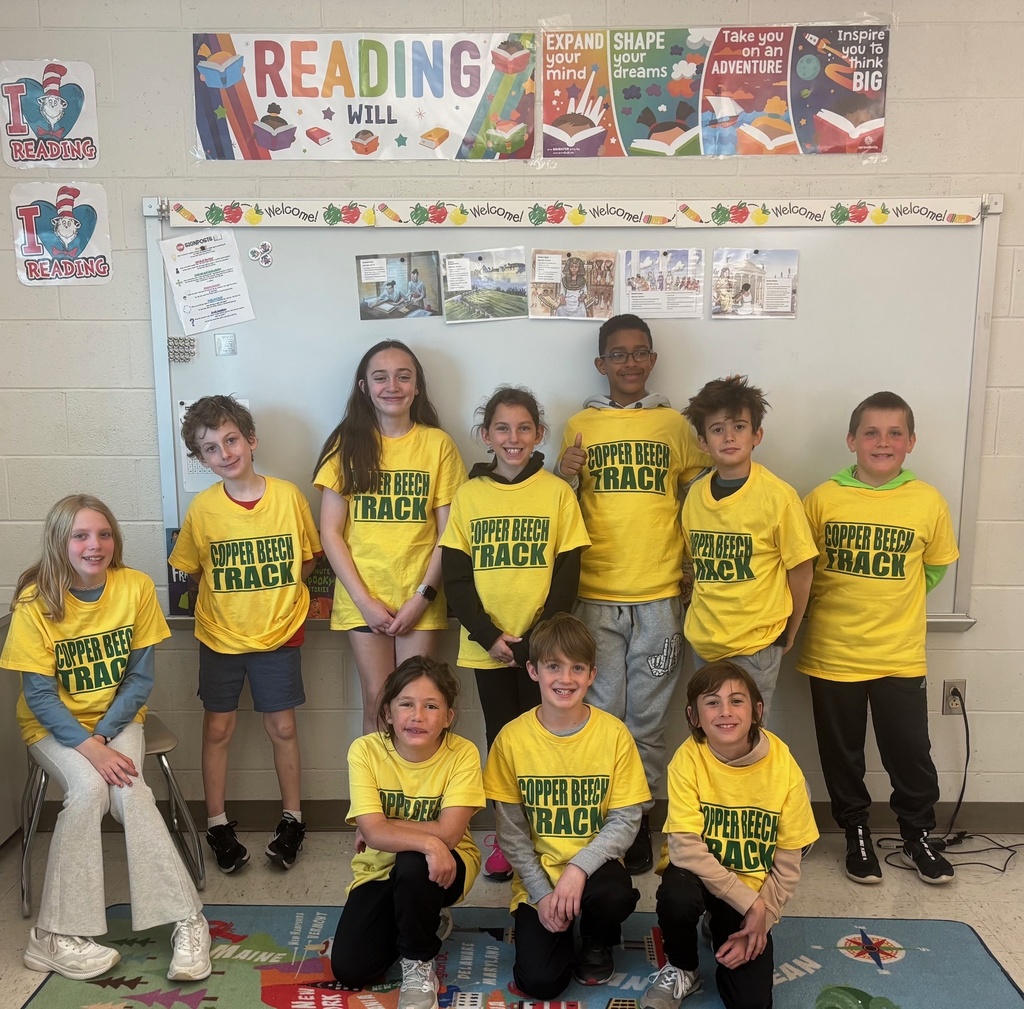 students smiling with their track team shirts