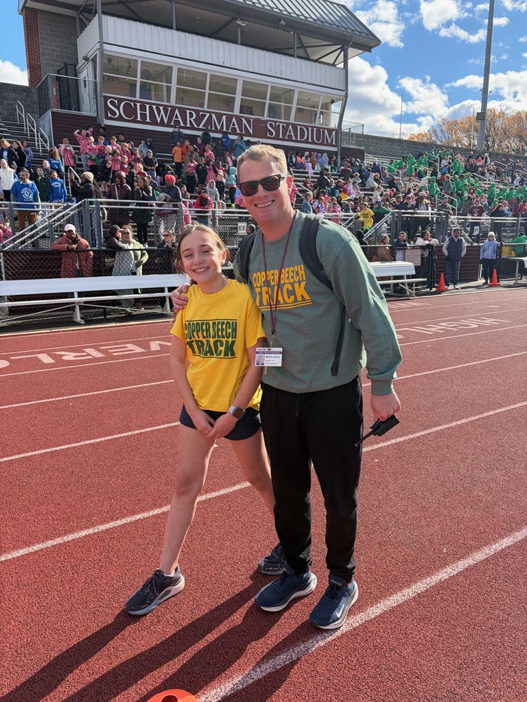 student and staff smiling at the track meet.