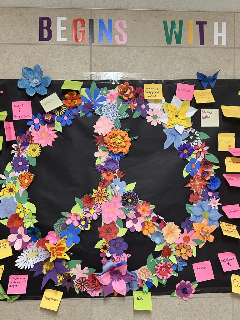 Flower peace sign on wall surrounded by stickers with good words. 