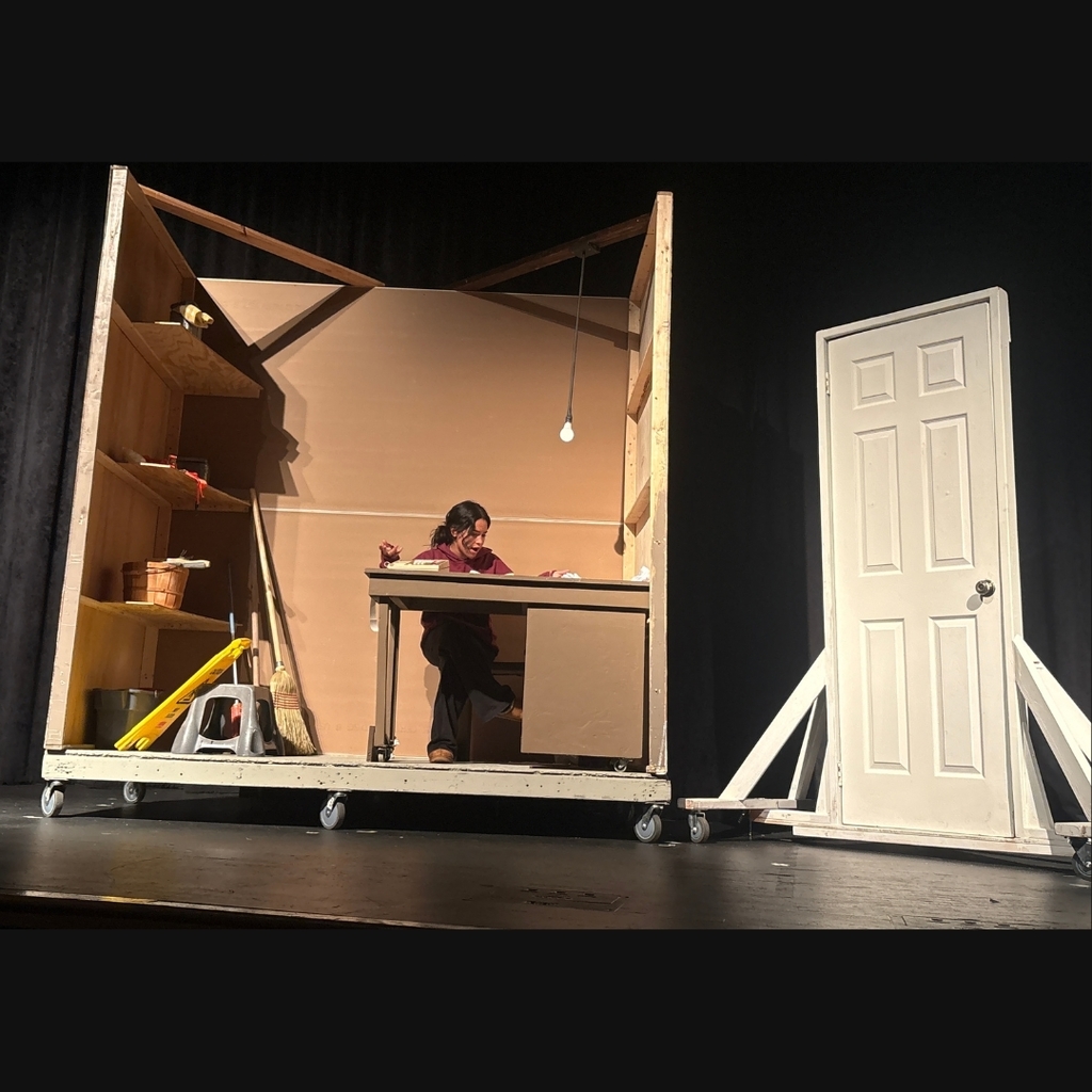 Actor on stage in the broom closet set