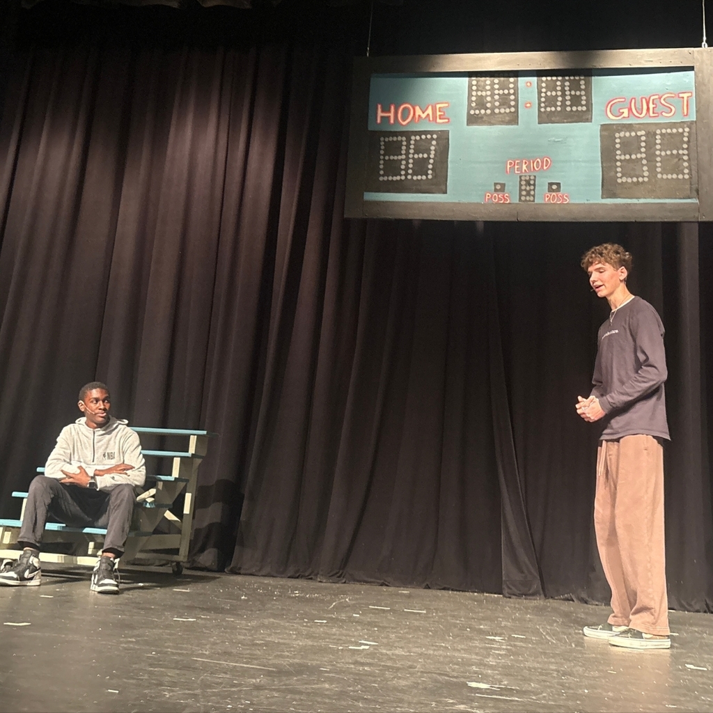 Actors on stage in the school gym set