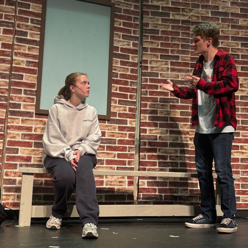 Actors on stage outside the school set