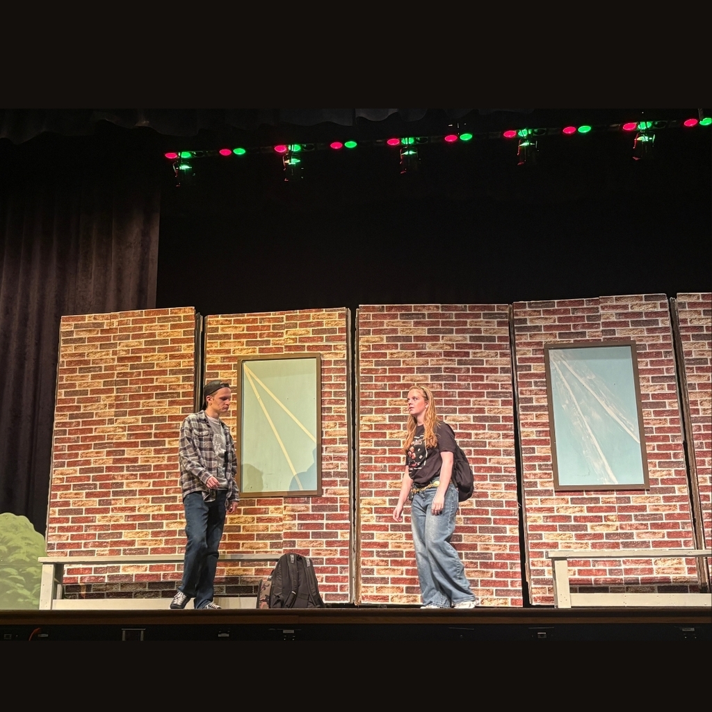 Actors on stage outside the school set