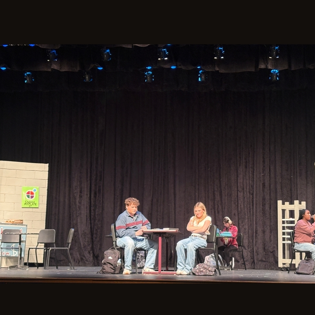 Actors on stage in the cafe set