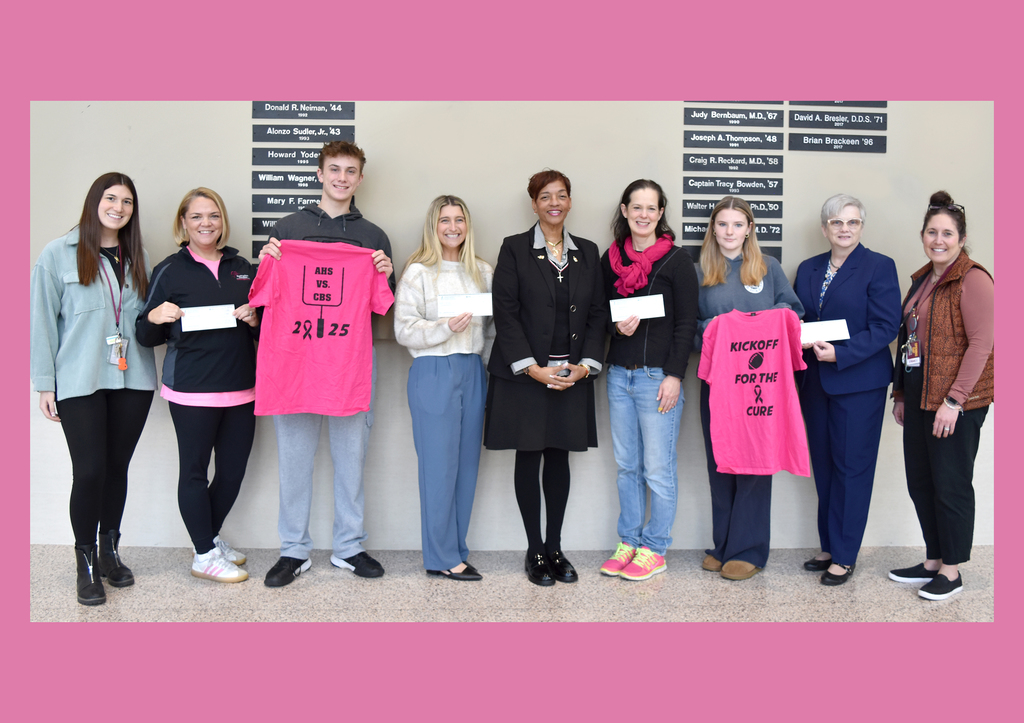 Representatives from charities, Dr. Swift and Ms. Peters pose with checks and breast cancer t-shirts