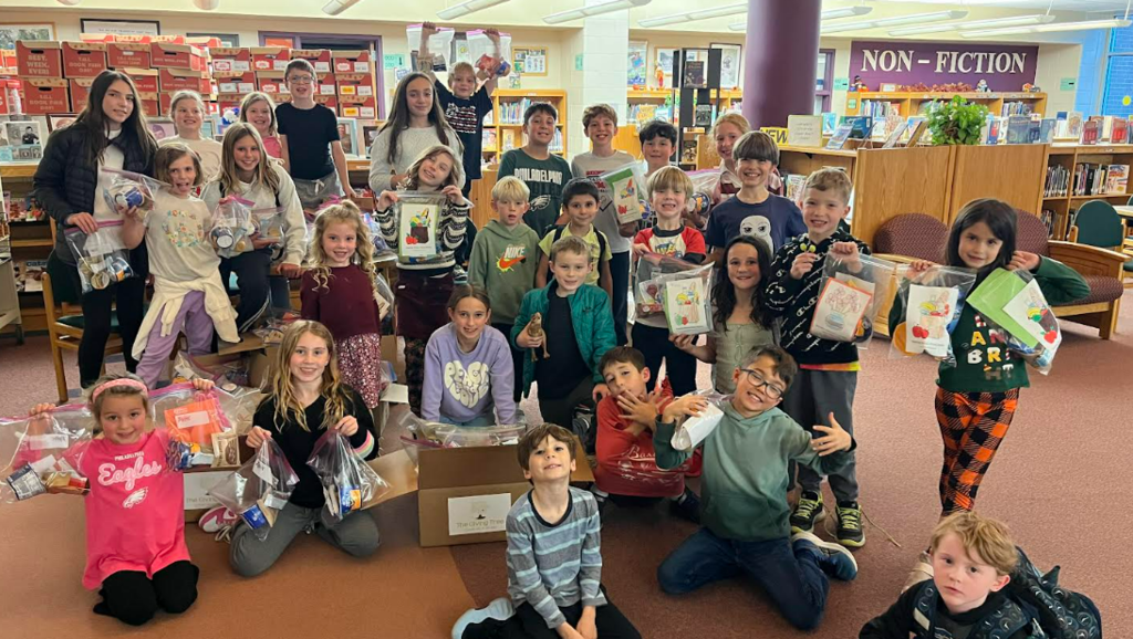 Students smiling with their snack bag donations