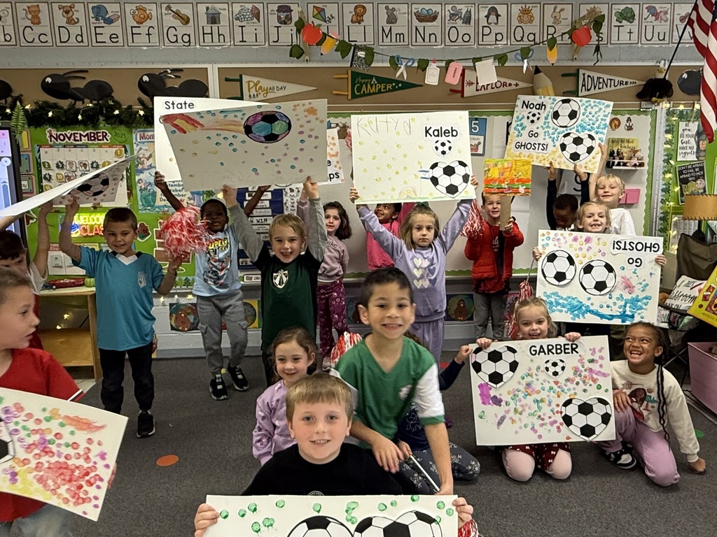 Students at Highland hold up signs they made