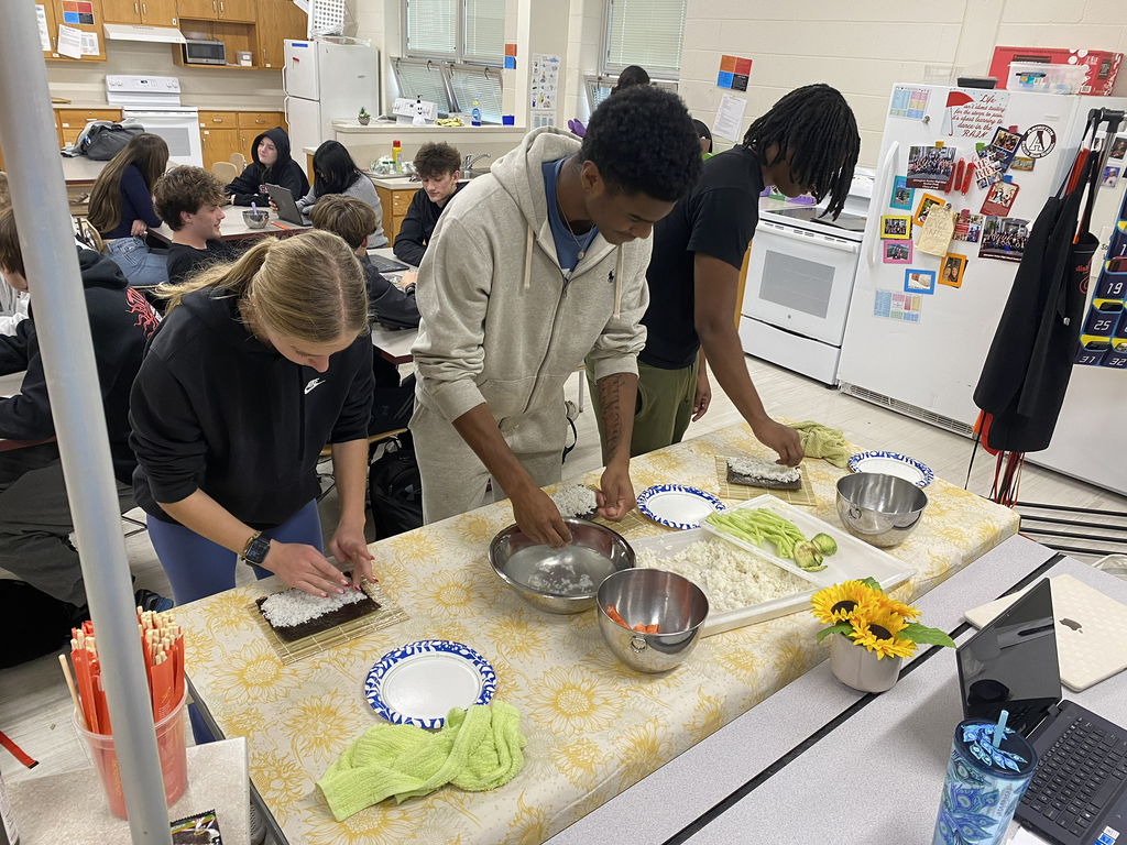 Students use ingredients to roll sushi