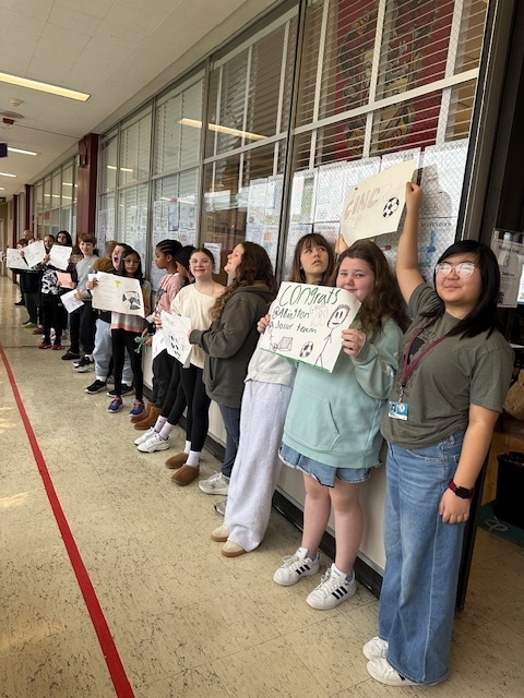 Image of 6th grade students making signs for high school soccer state champs.