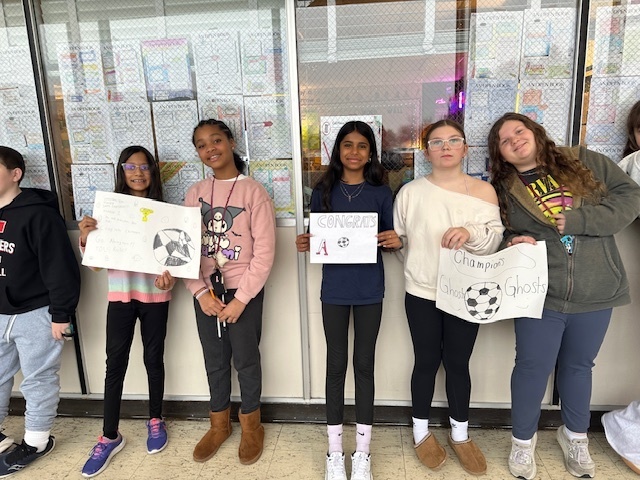 Image of 6th grade students making signs for high school soccer state champs.