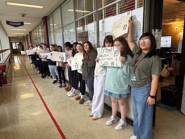 Image of 6th grade students making signs for high school soccer state champs.