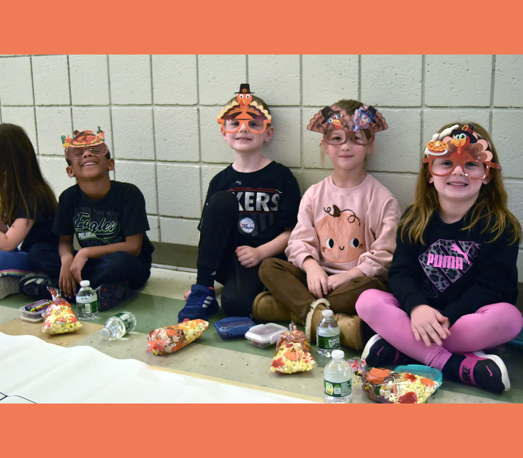 4 kindergarteners smile with their snacks during Friendsgiving