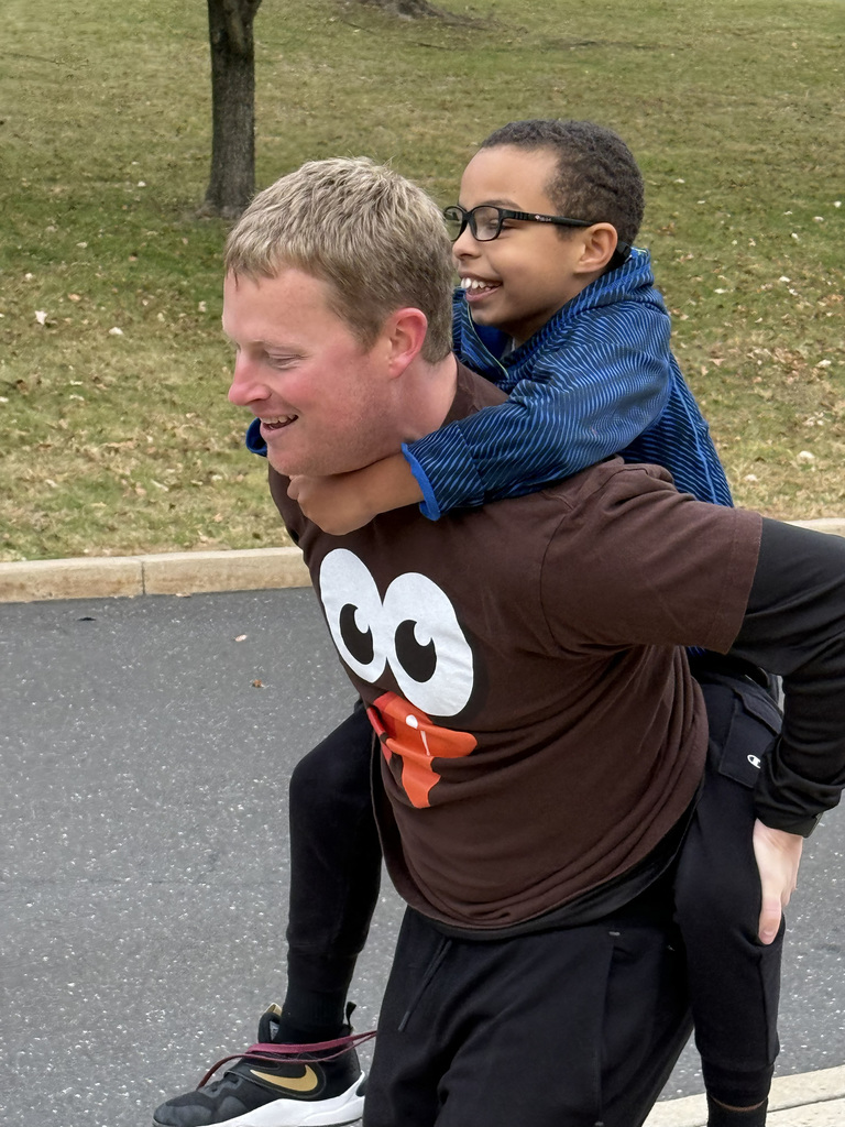 Staff carrying student on his back during  CB Turkey Trot