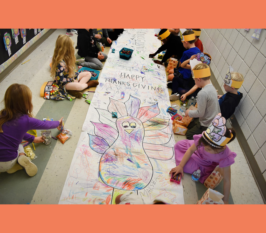 CB kindergarteners color a turkey on the floor during their Friendsgiving