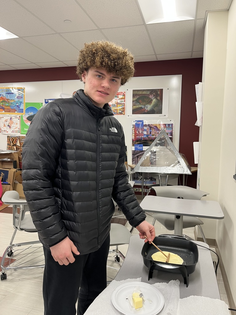 An ASHS  French 3 student cooks a crepe in class