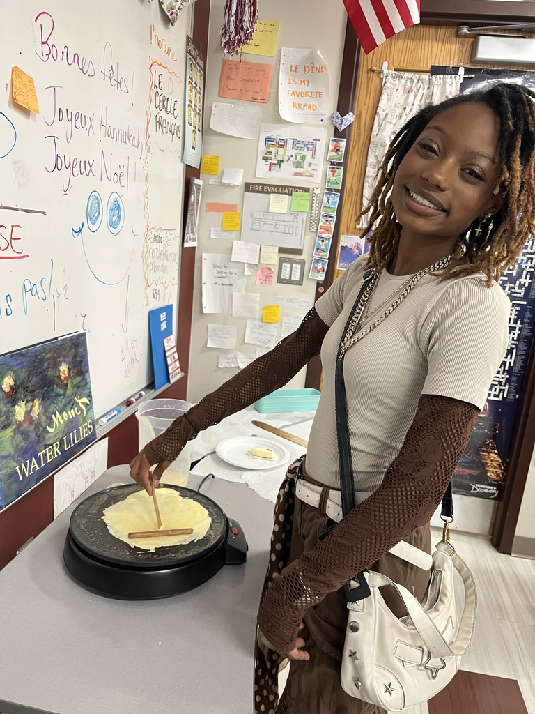 An ASHS  French 3 student cooks a crepe in class