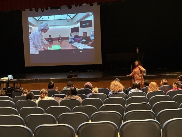AMS students view a Culinary student dicing an onion