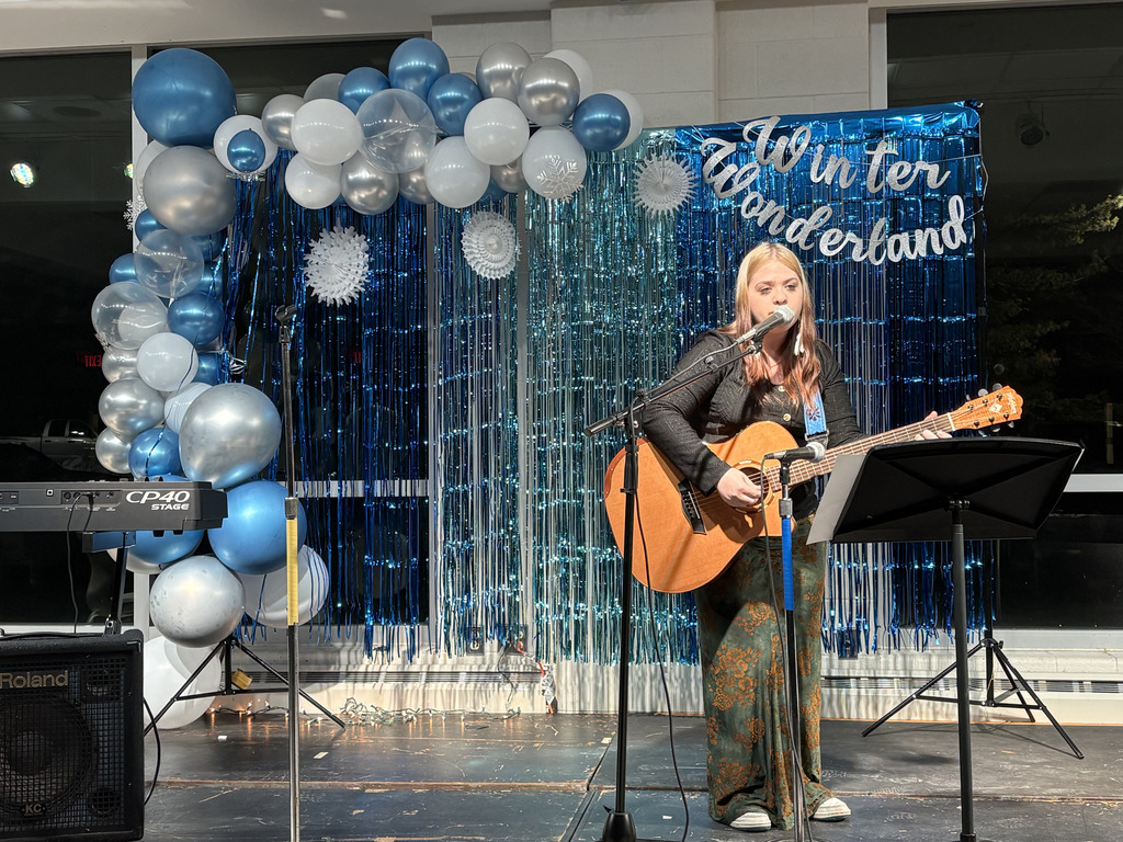 ASHS student playing guitar and signing at Open Mic Night